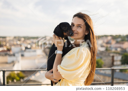 Female standing and holding pet close to face outside Female standing and holding pet close to face outside 110208953