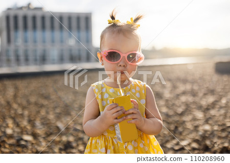 Baby standing and drinking juice Baby standing and drinking juice 110208960