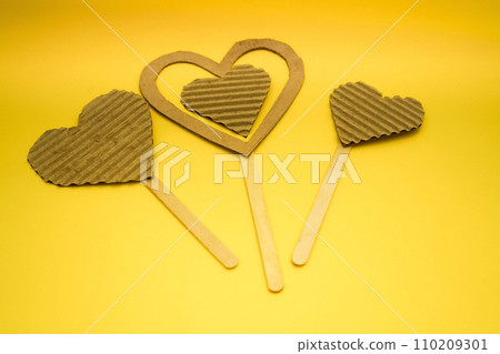 A hearts made of cardboard and thread on a yellow background. Valentine's day ideas are simple for kids. A hearts made of cardboard and thread on a yellow background. Valentine's day ideas are simple for kids. 110209301