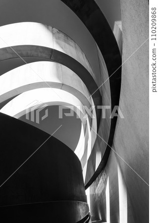 Striking monochrome architectural feature with sweeping curves and a dynamic interplay of light and shadow Striking monochrome architectural feature with sweeping curves and a dynamic interplay of light and shadow 110209868