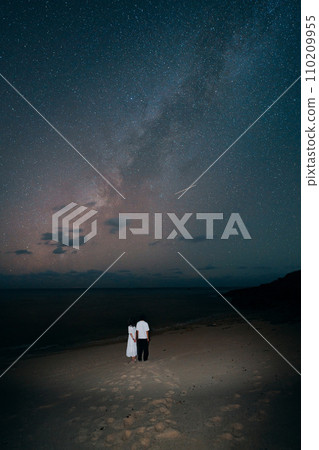 Couple staring at the Milky Way 110209955