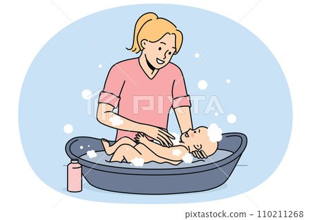 Smiling mother washing newborn baby 110211268