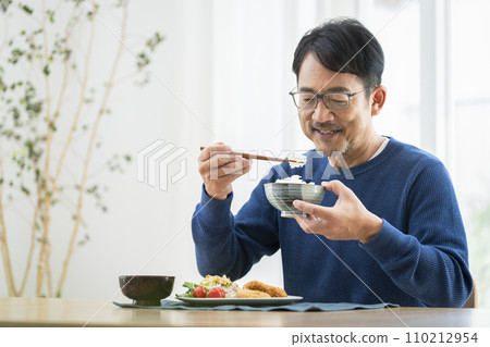 一名50多歲的男子在家吃飯 一名50多歲的男子在家吃飯 110212954