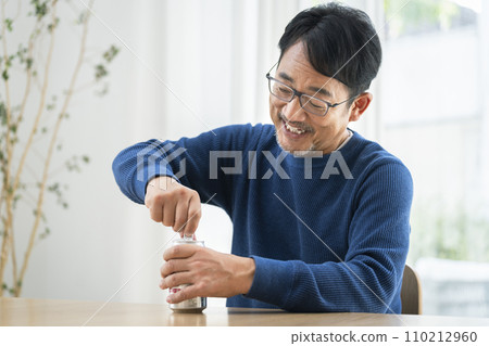中年男子打開一罐啤酒 中年男子打開一罐啤酒 110212960