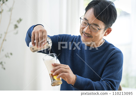 Middle-aged man pouring beer into a glass Middle-aged man pouring beer into a glass 110213095