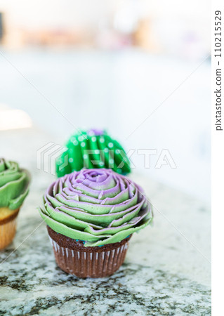 Using buttercream frosting, vanilla and chocolate cupcakes are intricately decorated to resemble various types of cactuses, creating a delightful and visually engaging dessert that showcases Using buttercream frosting, vanilla and chocolate cupcakes are intricately decorated to resemble various types of cactuses, creating a delightful and visually engaging dessert that showcases 110215529