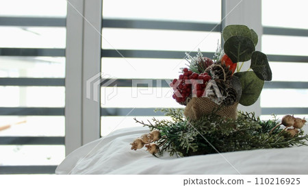 decorative composition on a snow-white bed against the background of a window 110216925