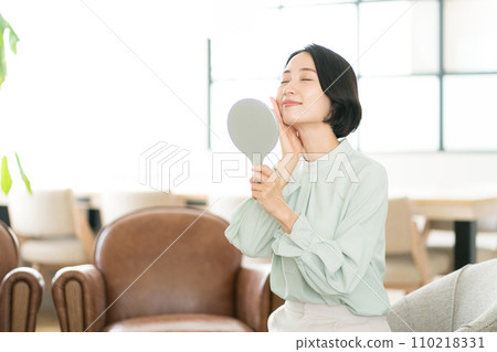 微笑一名中間婦女的婦女看鏡子 微笑一名中間婦女的婦女看鏡子 110218331