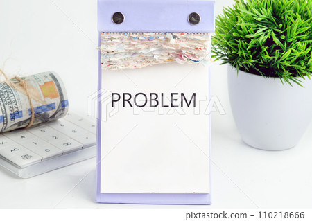PROBLEM text, word, inscription on a desktop calendar on a white background next to money and a green flower PROBLEM text, word, inscription on a desktop calendar on a white background next to money and a green flower 110218666