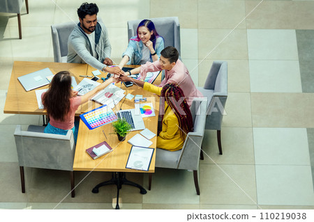 mixed-race journalist fashion designers working together in a bright office 110219038