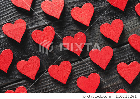 Red wooden hearts on black wooden background 110219261