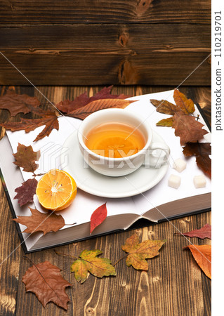 Cup of tea with autumn leaves background on wooden table 110219701