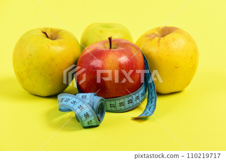 Measuring tape or flexible ruler in blue color and apples Measuring tape or flexible ruler in blue color and apples 110219717