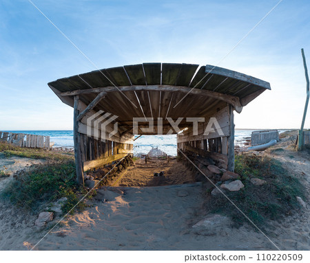 Wooden Boathouse and Rails at Sunset on Secluded Beach 110220509