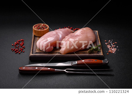 Fresh chicken fillet on a dark concrete table with spices and herbs 110221324