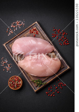 Fresh chicken fillet on a dark concrete table with spices and herbs Fresh chicken fillet on a dark concrete table with spices and herbs 110221330