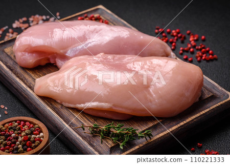 Fresh chicken fillet on a dark concrete table with spices and herbs Fresh chicken fillet on a dark concrete table with spices and herbs 110221333