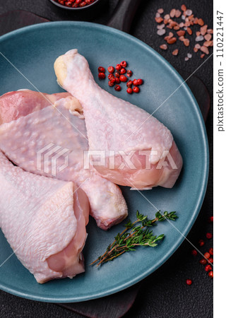 Raw chicken legs with salt, spices and herbs on a dark concrete background 110221447