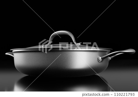 Stainless steel frying pan with glass lid and chrome cookware on black 110221793