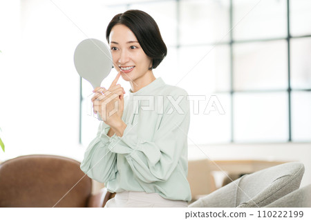 中年婦女對著鏡子檢查牙齒 110222199