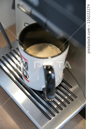 Coffee mug with coffee crema under the outlet of a fully automatic coffee machine 110222274