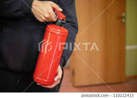man is holding fire extinguisher in the office. The concept of fire safety 110222415