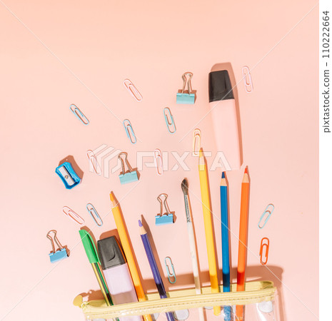 Stationery spills out of a pencil case on a beige background 110222664