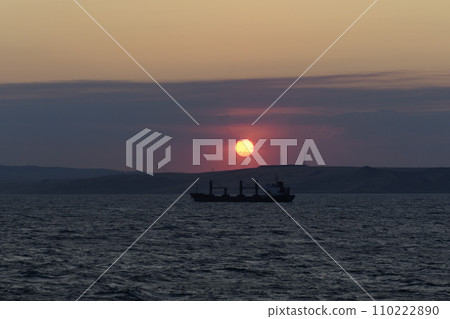 Cargo vessel at sea. Bulk carrier. Dry cargo ship at sunset. Cargo vessel at sea. Bulk carrier. Dry cargo ship at sunset. 110222890