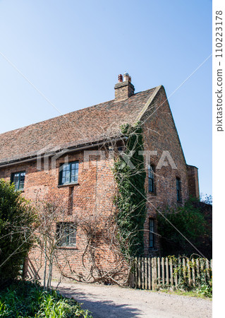 A historic brick building covered in ivy under a clear sky in Osterley Park on the outskirts of London A historic brick building covered in ivy under a clear sky in Osterley Park on the outskirts of London 110223178