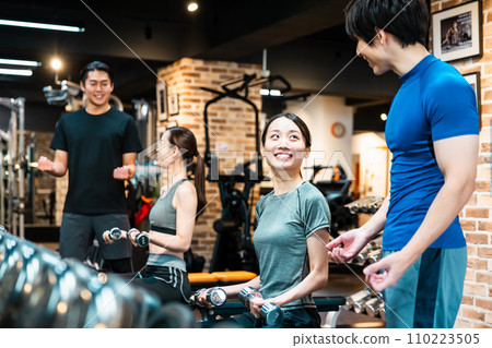 年輕女子和男教練在健身房進行重量訓練 110223505