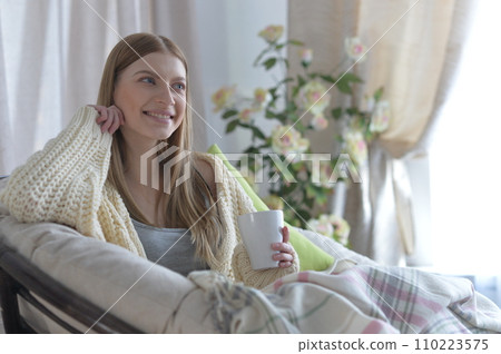 Portrait of young woman in pajamas on bed with fluffy plaid Portrait of young woman in pajamas on bed with fluffy plaid 110223575
