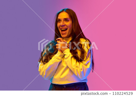 Positive surprised, young, emotional woman with freckles stands against gradient purple-pink background. Concept of human emotions. 110224529