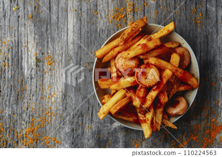 typical german currywurst and chips in a plate 110224563