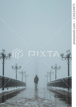 silhouette lonely man maniac walks on foggy bridge with lanterns in winter with snow and fog mist silhouette lonely man maniac walks on foggy bridge with lanterns in winter with snow and fog mist 110224973