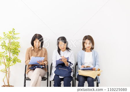 Woman filling out a clipboard in the waiting room 110225080