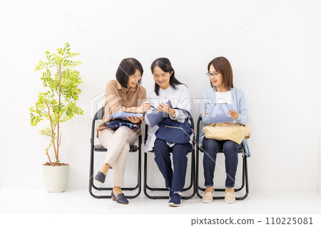 Woman filling out a clipboard in the waiting room 110225081