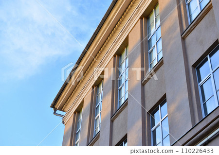 The facade of a classic building in the city. The windows of the building are in the old style. Beautiful windows and yellow walls of the house. The facade of a classic building in the city. The windows of the building are in the old style. Beautiful windows and yellow walls of the house. 110226433