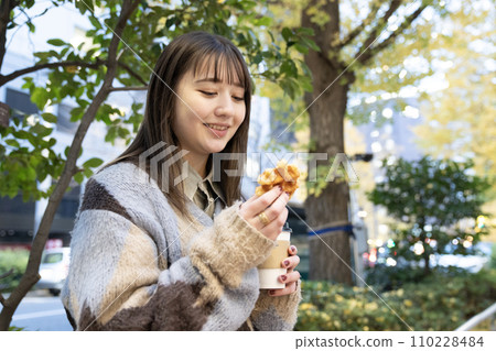 Woman with waffles outdoors 110228484