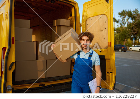 Deliveryman carrying cardboard boxes with purchased items in hand Deliveryman carrying cardboard boxes with purchased items in hand 110229227