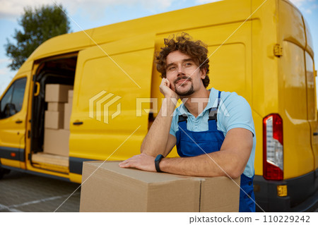Portrait of courier enjoying rest leaning at parcel box stack Portrait of courier enjoying rest leaning at parcel box stack 110229242