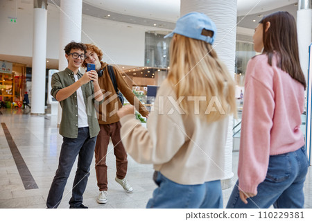 Happy friends spending time at shopping mall taking photo Happy friends spending time at shopping mall taking photo 110229381