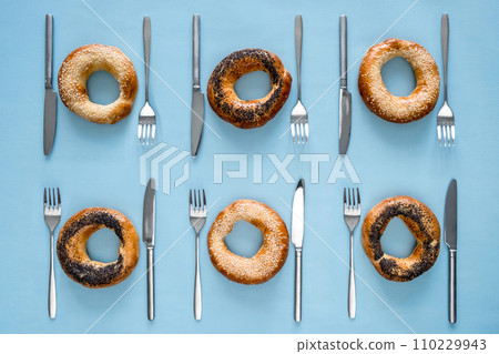 Small dry bagels with cutlery top view 110229943