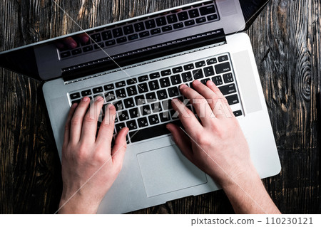 hands typing on grey notebook hands typing on grey notebook 110230121