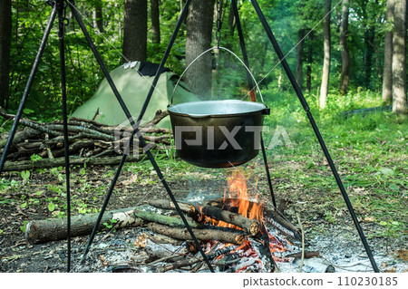 Prepearing a meal on an open fire 110230185