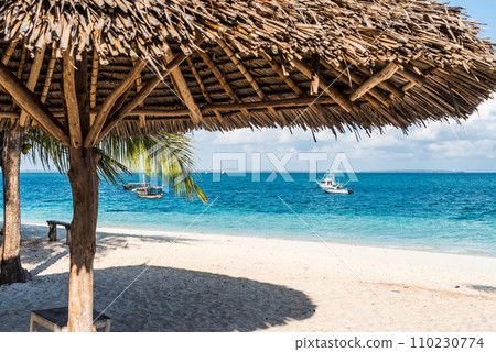 beautiful view of blue ocean from beach with straw umbrella 110230774