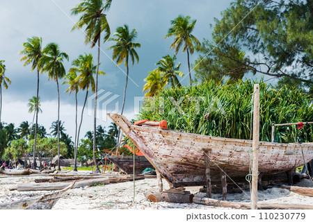 old wooden fishing boat with paddles on a beach old wooden fishing boat with paddles on a beach 110230779