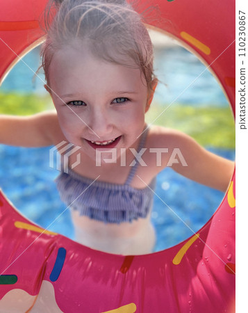 Baby girl smiling in swimming pool. Child having fun in swimming pool Baby girl smiling in swimming pool. Child having fun in swimming pool 110230867