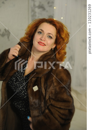 fashion studio photo of gorgeous sensual woman with blond hair in luxurious dress and fur coat  110231269