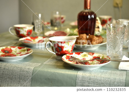 The remaining dishes on the table and a bottle of wine. The remaining dishes on the table and a bottle of wine. 110232835