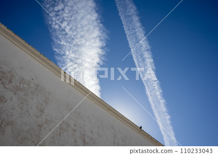 Typical white archtecture and blue sky with chemtrails 110233043